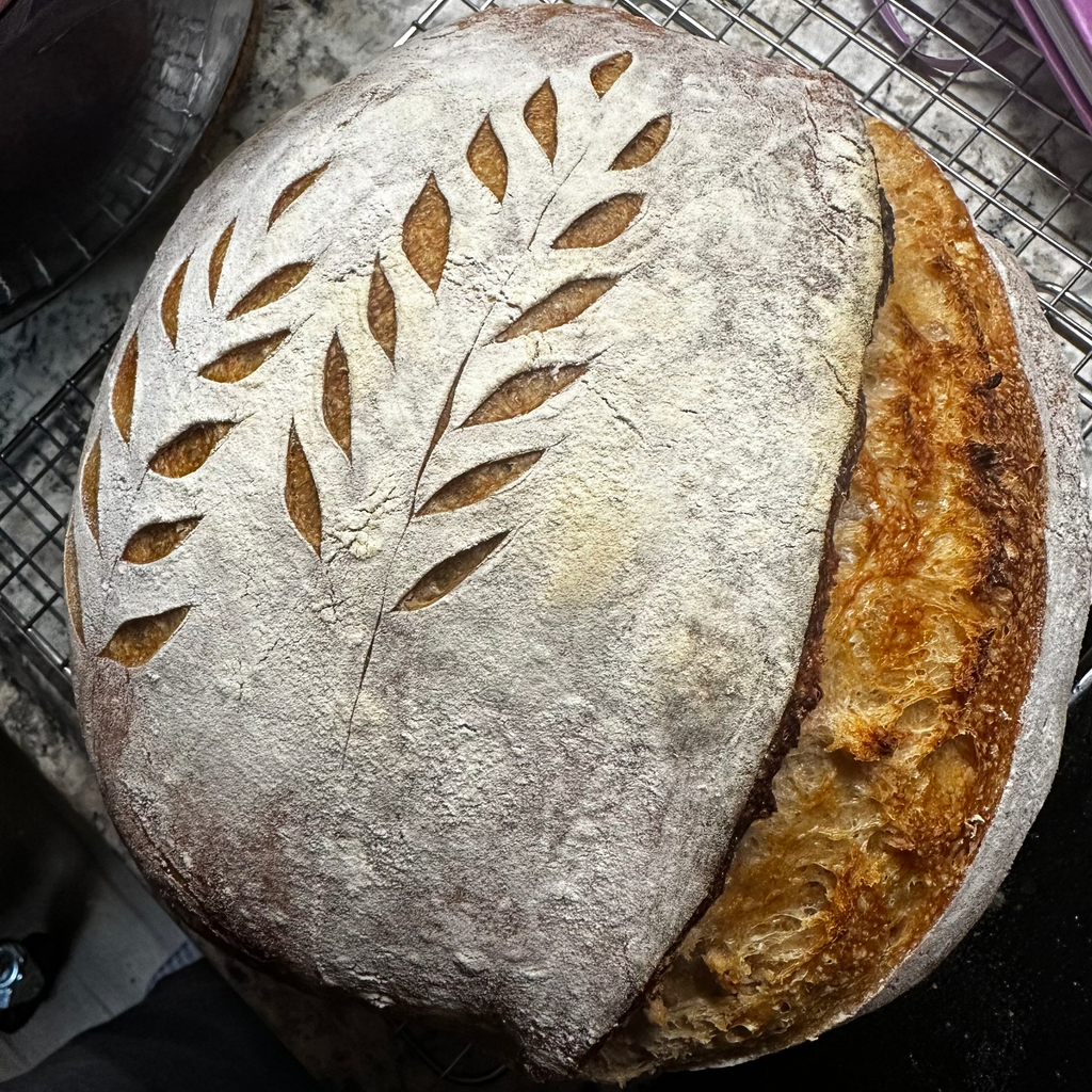 Loaf of bread with leaf patterns on a cooling rack